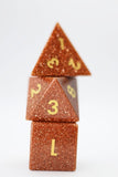 Three metallic gold dice stacked on a white background