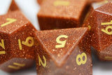 Close-up of brown polyhedral dice with gold numbers on a white background