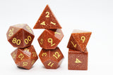 Set of polyhedral dice with gold numbers on a white background