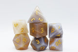 Set of polyhedral dice with gold numbers on a white background