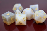 Set of polyhedral dice with gold numbers on a reflective surface