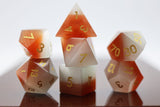 Set of polyhedral dice with red and white gradient on a reflective surface