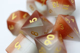 Set of polyhedral dice with gold numbers on a white background