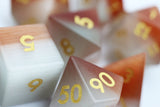 Close-up of polyhedral dice with gold numbers on a white background
