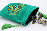 Green velvet dice bag with embroidered dragon design, accompanied by dice on a white background