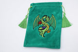 A green velvet drawstring pouch with a green dragon embroidered on the front, featuring green tassels on both sides, set against a plain white background.