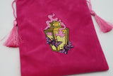 Pink drawstring bag with embroidered design on a white background
