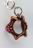Copper charm with a pink bead on a white background