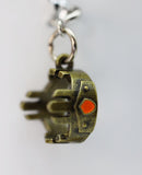 Bronze elephant charm with a red gem on a white background