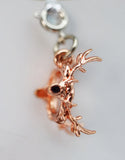 Rose gold deer charm on a white background