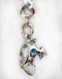 Silver charm with a blue gemstone on a white background