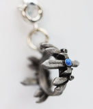 Silver pendant with a blue gemstone on a white background