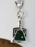 Silver charm with green stone on a white background
