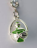 Silver and green pendant on a gray background
