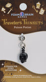 Black skull charm on a 'Traveler's Trinkets' card by Foam Brain Games.