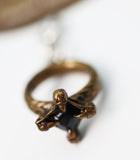 Bronze ring with a central black stone on a white background