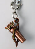Copper charm with green accents on a gray background