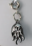 Silver flame-shaped charm on a clear background