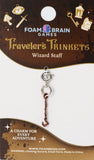 Key-shaped charm on Foam Brain Games packaging with decorative elements.