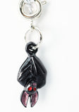 Black and pink pendant with red stones on a white background