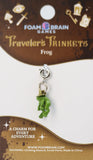 Green frog charm on a Foam Brain Games packaging with branding and product details.
