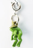 Green frog charm with a gold hat on a white background