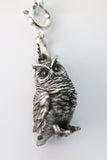 Silver owl charm on a white background
