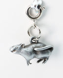 Silver rodent charm on a clear background