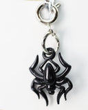 Black spider charm on a white background