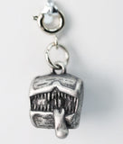Silver charm resembling a building on a white background