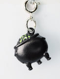 Black charm with green accents on a white background