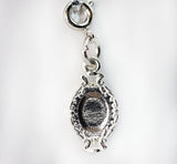 Silver charm with intricate design on a white background