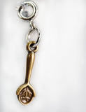 Gold spoon-shaped charm on a white background
