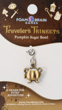Gold pumpkin-shaped charm on Foam Brain Games packaging
