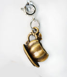 Gold teacup charm on a white background
