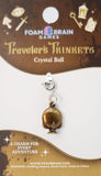 Crystal ball charm on a Foam Brain Games branded card with decorative elements.