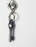 Silver key-shaped charm on a white background