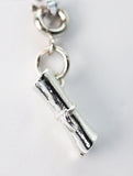 Silver charm resembling a rolled-up scroll on a white background