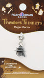 Traveler's Trinkets Plague Doctor charm on a Foam Brain Games packaging