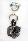 Metallic D20 dice charm on a white background