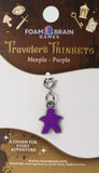 Purple meeple charm on a Foam Brain Games card with branding and product details.