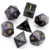 Set of polyhedral dice with black and gold numbers on a white background
