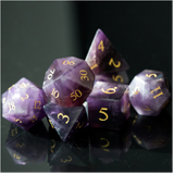 Set of purple polyhedral dice with gold numbers on a reflective black surface.