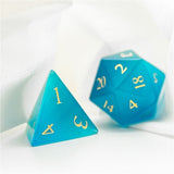 Two turquoise polyhedral dice with yellow numbers on a white background