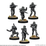 Six miniature figures of soldiers with weapons on black bases against a white background.