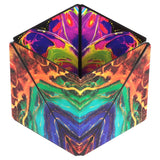 A 3D geometric cube-shaped puzzle box with a highly vibrant, symmetrical marbled pattern in purple, green, blue, orange, and yellow, isolated on a white background.