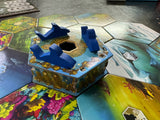 Board game piece with blue and gold design on a colorful board