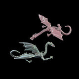 Two dragon figurines, one pink and one silver, on a black background