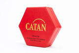 Red hexagonal Catan box with gold text on a white background