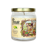 A glass jar candle with a gold metal lid and a cream-colored label featuring an illustration of summer garden animals and vegetables. The label reads 'Feast' and 'Barnyard Sweet's Summer Salad'.